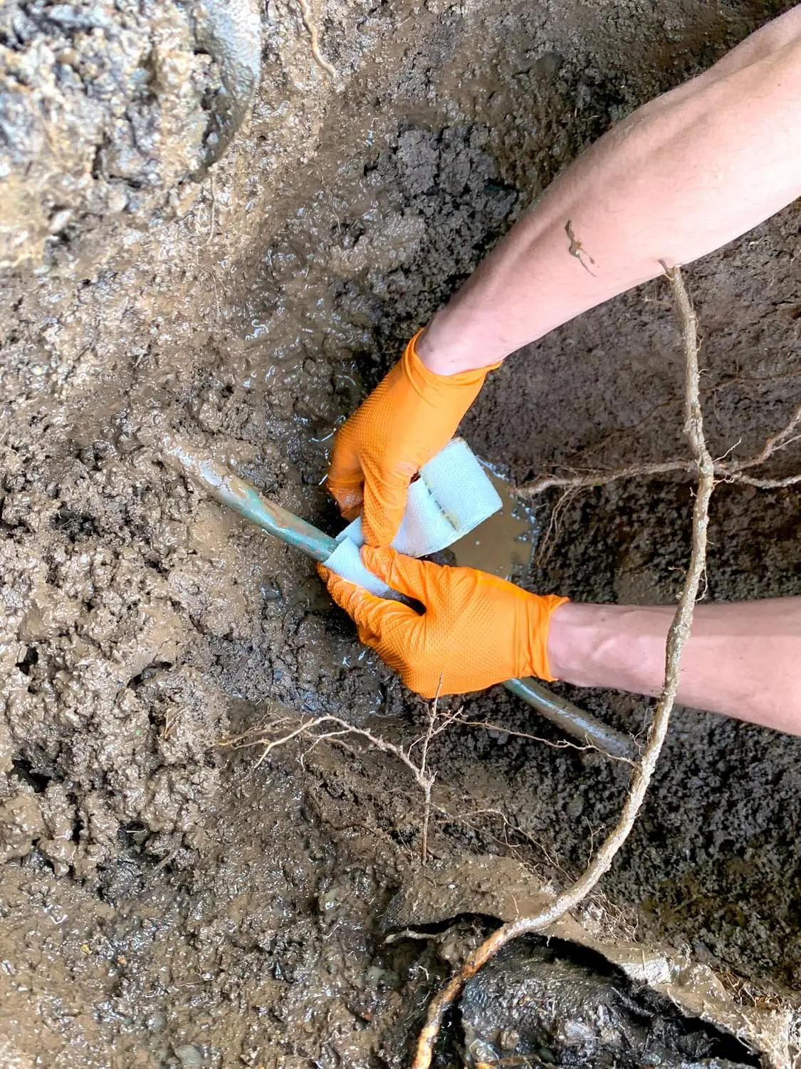 Repairing a buried water line in a muddy trench