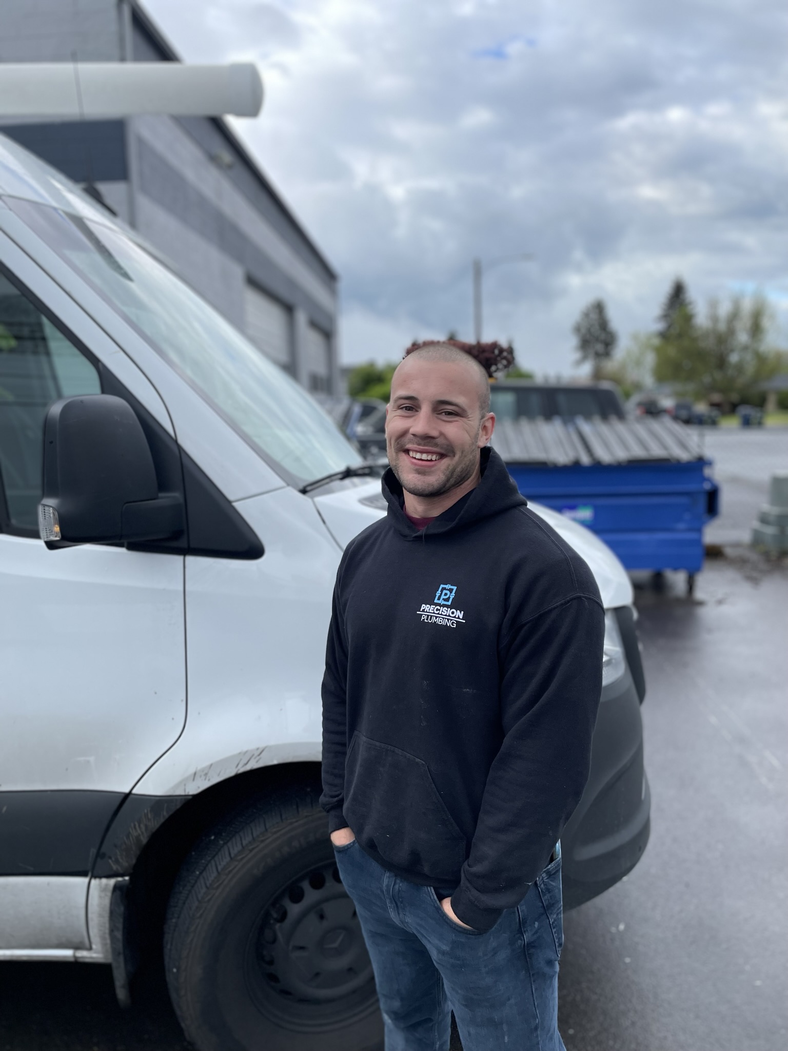 Precision Plumbing team member standing beside a service van