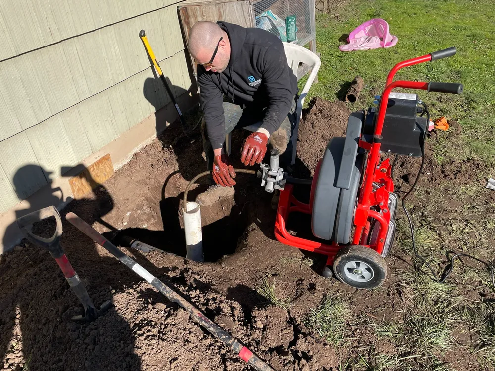 Technician running a drain machine at a home