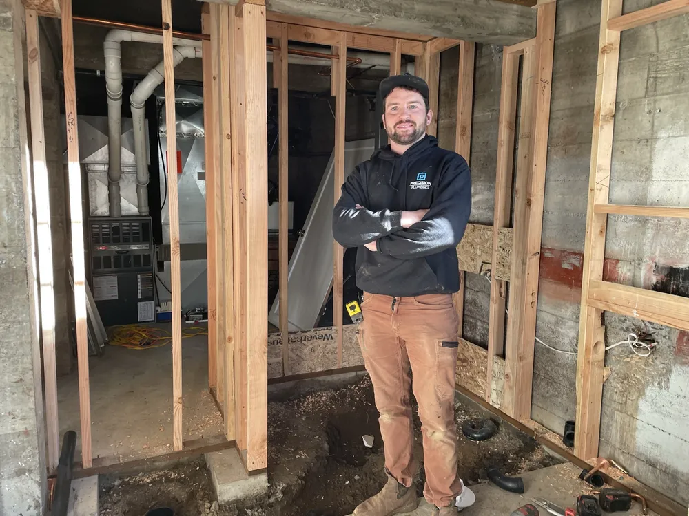 Plumber roughing in drain lines in a framed wall