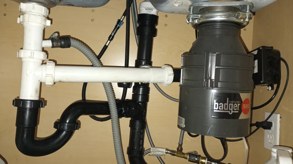 Garbage disposal and drain assembly under a sink