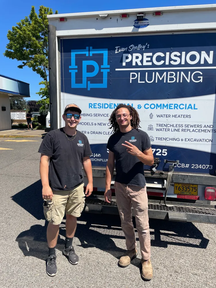 Precision Plumbing crew in front of a service truck