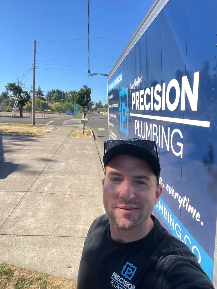 Technician at the door of a Precision Plumbing truck