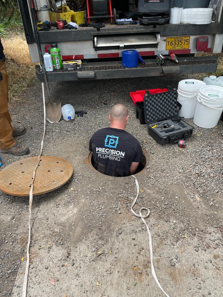 Technician inspecting a line from inside the excavation
