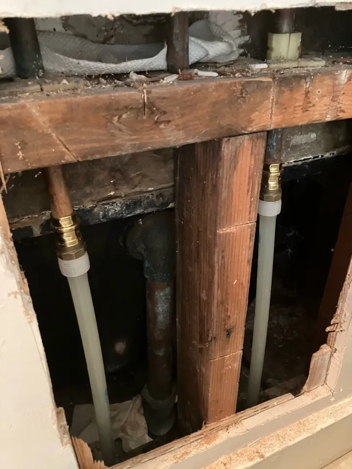 Water line exposed in the dirt beside a home